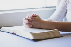 woman praying with her Bible open